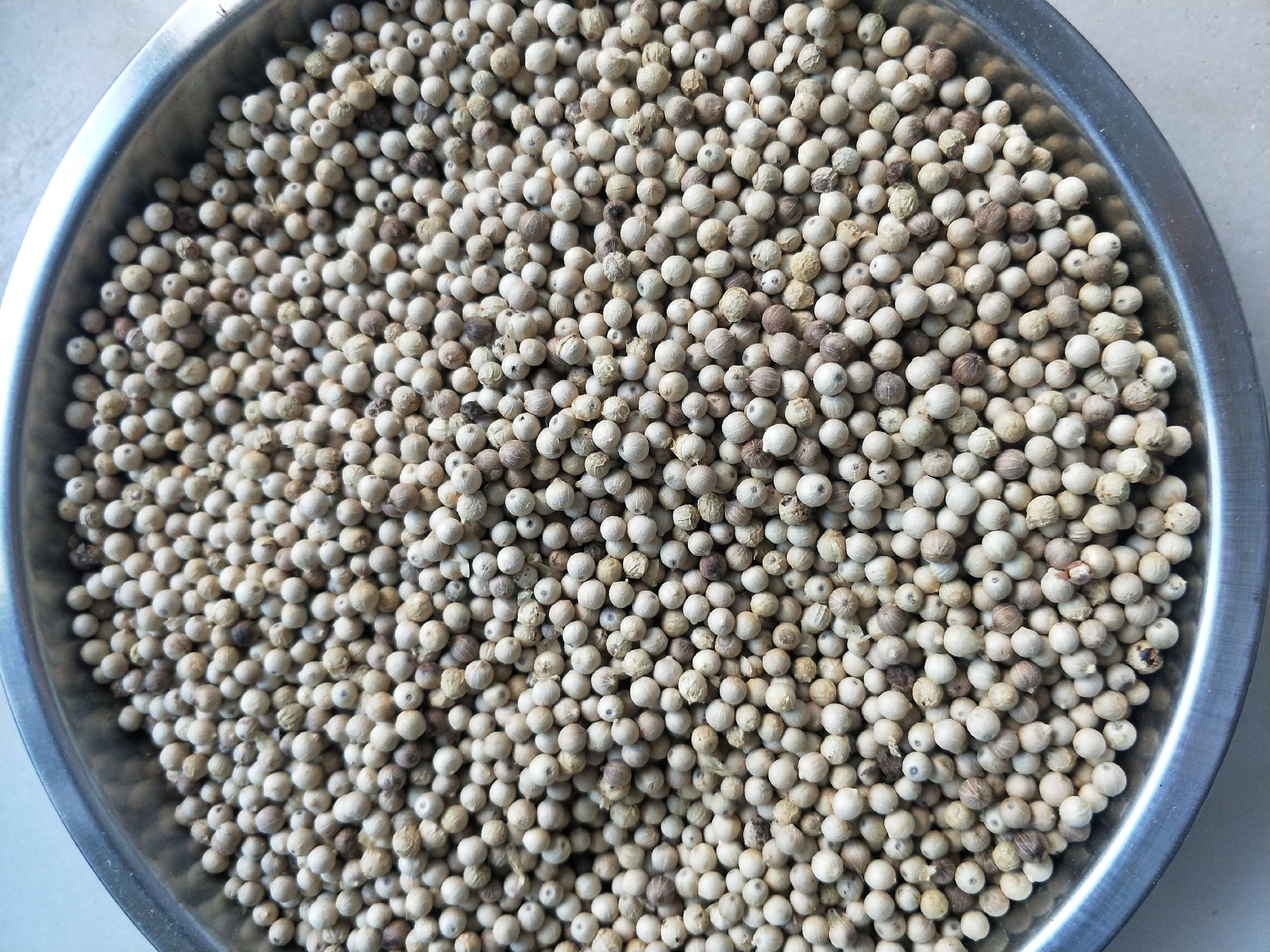 正在翻炒的胡椒粒,锅中热气升腾,香气扑鼻 炒胡椒粒的炒制过程