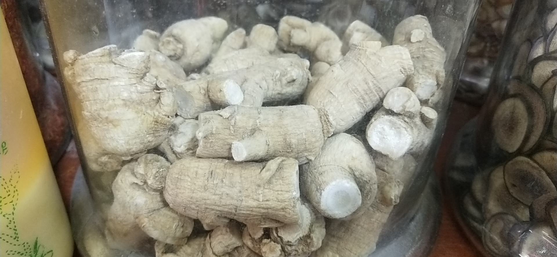 图片说明:玻璃瓶中盛放的藏红花三七酒,颜色呈琥珀色,药材清晰可见 藏红花三七泡酒的成品展示