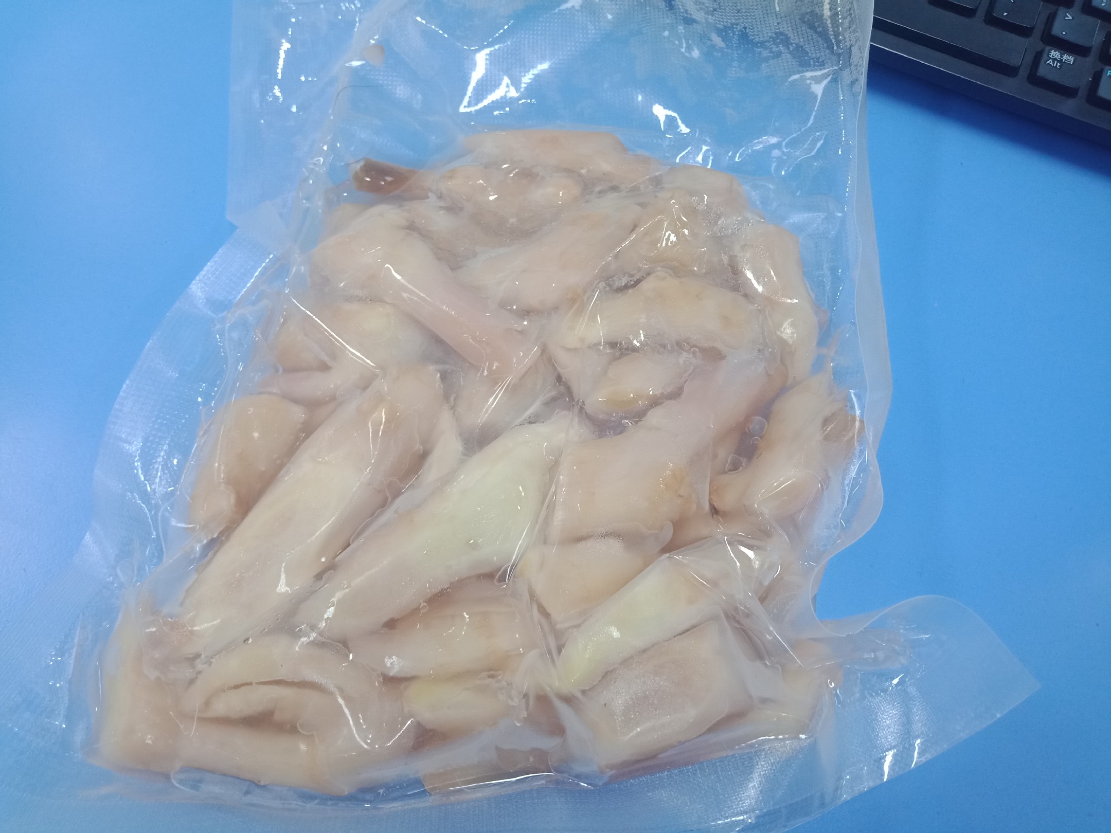 图示:三块完整带泥生姜被分别装入透明食品级真空袋,袋体平整无褶皱,真空泵正在抽气,背景为家用冰箱冷藏室底层隔板,温度计显示4.0℃ 真空密封冷藏保存生姜操作示意图