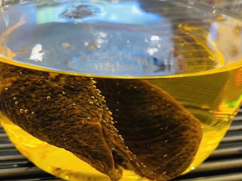 西洋参陈皮茶饮成品与原材料的组合摆拍图,营造自然养生氛围 茶饮摆拍图,旁边摆放有西洋参片和陈皮原料