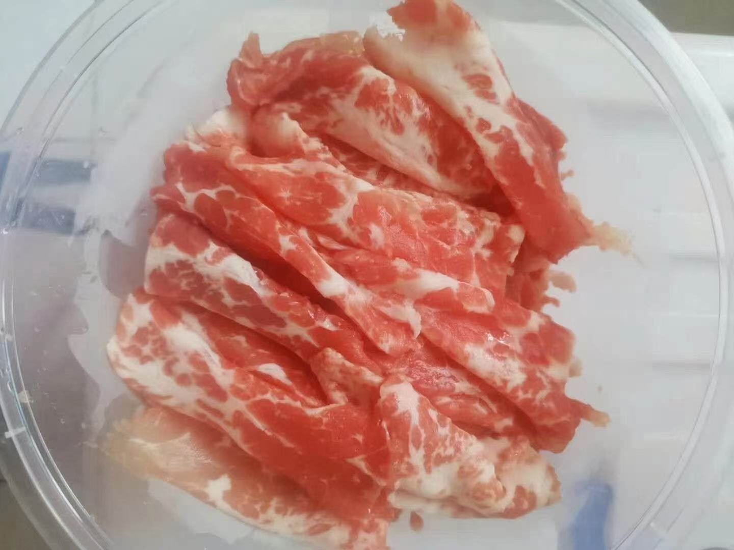 一盘切好的花牛苹果片摆放在木质餐盘中，旁边配有蜂蜜和坚果，背景为冬日窗景