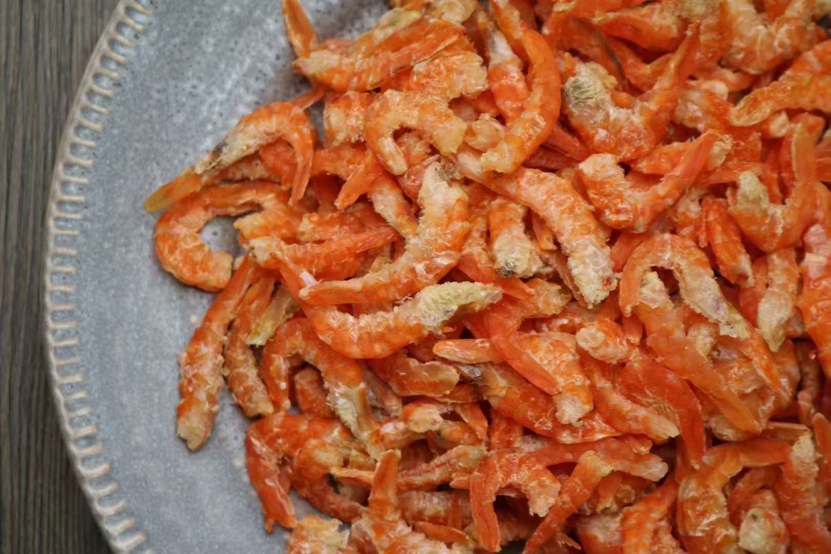 锅中正在翻炒的螺丝椒与虾仁,香气四溢,颜色鲜亮 翻炒中的螺丝椒与虾仁