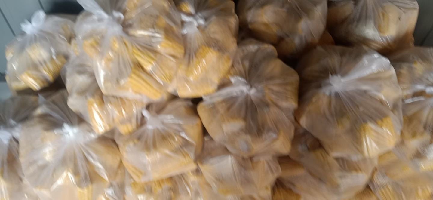 开放式冷冻货架上整齐排列不同品牌的速冻甜玉米粒包装袋,标签清晰可见配料表、营养成分表和生产日期,消费者正在挑选,背景有温度计显示-18°C 超市冷柜中陈列的多种速冻甜玉米产品对比图
