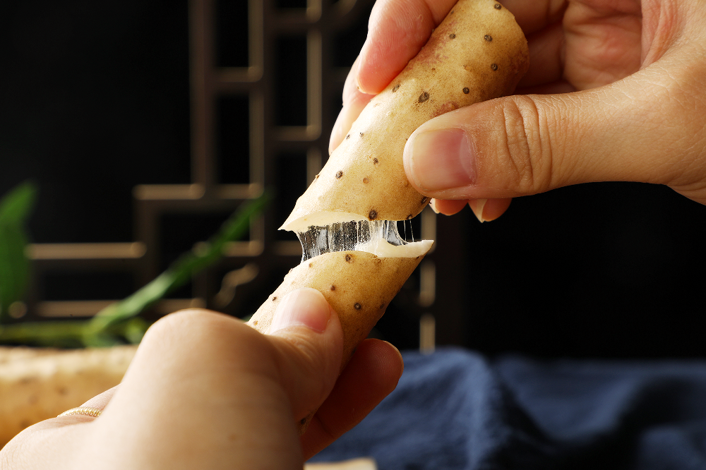 糯山药蒸制后断面特写：呈现半透明琥珀色光泽，筷子轻挑可见连续拉丝长度达10cm，丝体均匀无断裂