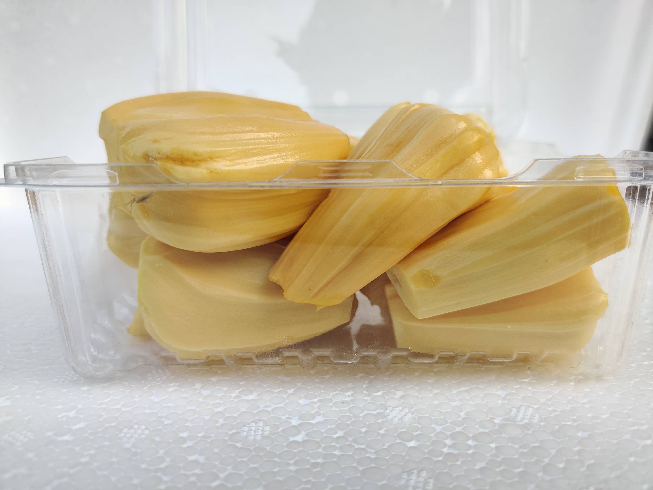 玻璃碗中盛放着新鲜水果,旁边是一罐天然蜂蜜,展现出健康饮食的搭配方式 蜂蜜与水果搭配图