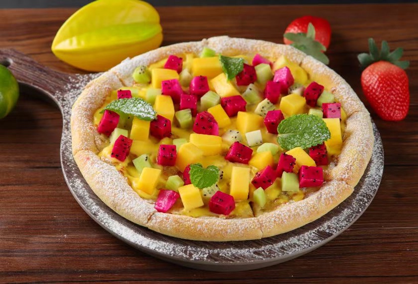 一张木质餐桌上的早餐组合,包括吐司、酸奶碗、一杯柚子牛奶饮品和水果拼盘 柚子与牛奶饮品搭配场景图