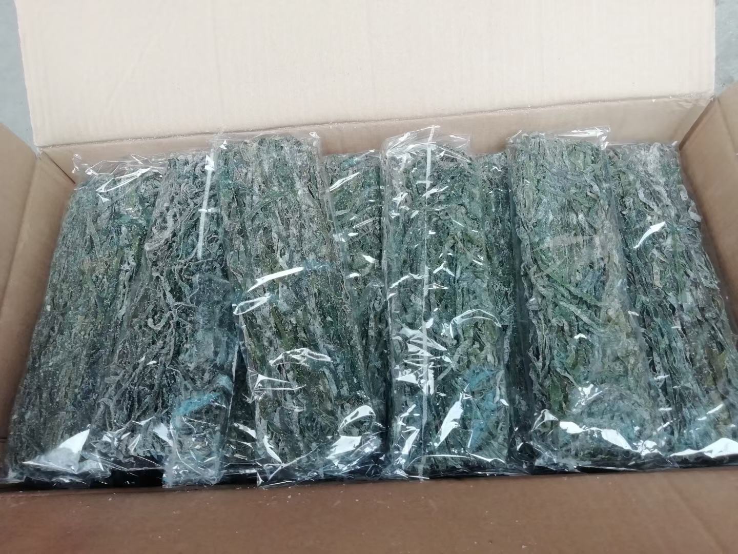 超市冷藏区货架上整齐摆放着不同品牌的即食海带产品,包括真空包装的凉拌海带丝、软糯海带结、辣味海带片、原味海带苗等,包装色彩鲜明,标签清晰可见‘低脂’‘高纤维’‘即食’等字样,背景有消费者正在挑选,体现产品的多样性与市场普及度 超市货架上的各类海带产品陈列