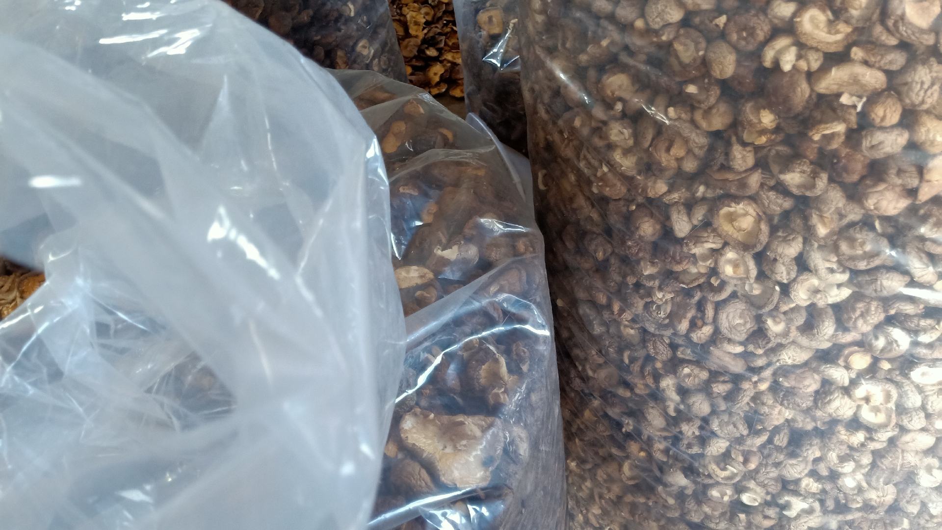 一包市售干香菇的外包装特写,清晰展示生产日期、保质期、储存条件等信息,背景为厨房台面,旁边放有量勺和剪刀,体现家庭使用场景 干香菇包装标签示例