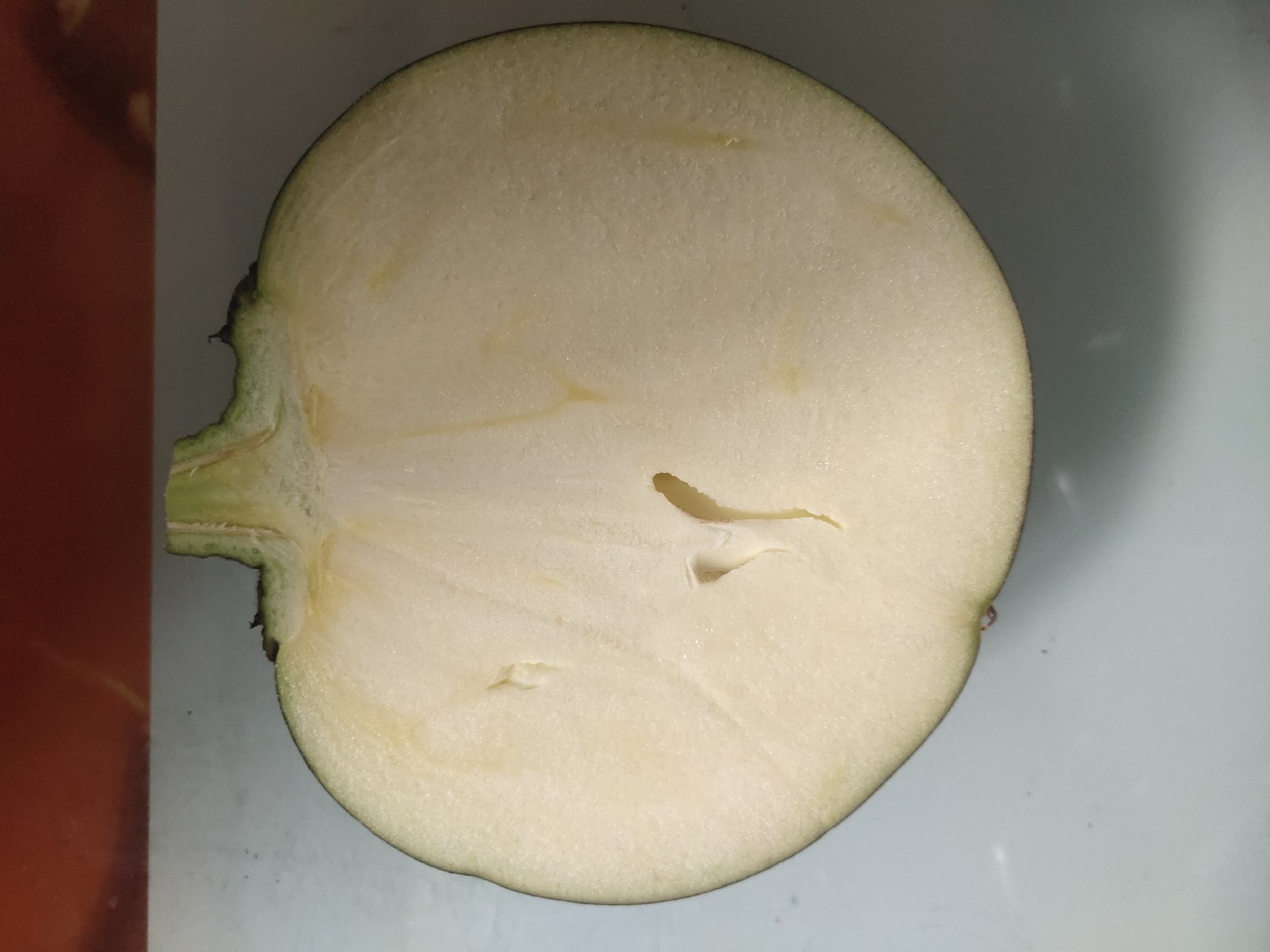 新鲜的发茄摆放在案板上,表皮光滑,颜色紫亮,旁边有切开的横截面展示其内部结构 发茄实物图