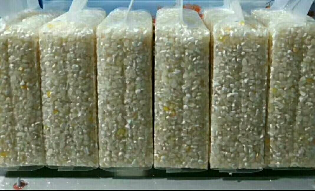 一张整洁的木质桌面上陈列着金穗香小米的多种商品形态:左侧是透明袋装原米,中间是礼盒装精品米,右侧是即食小米粥杯和小米粉罐,背景附有二维码溯源标签和绿色食品认证标识 金穗香小米系列产品展示图