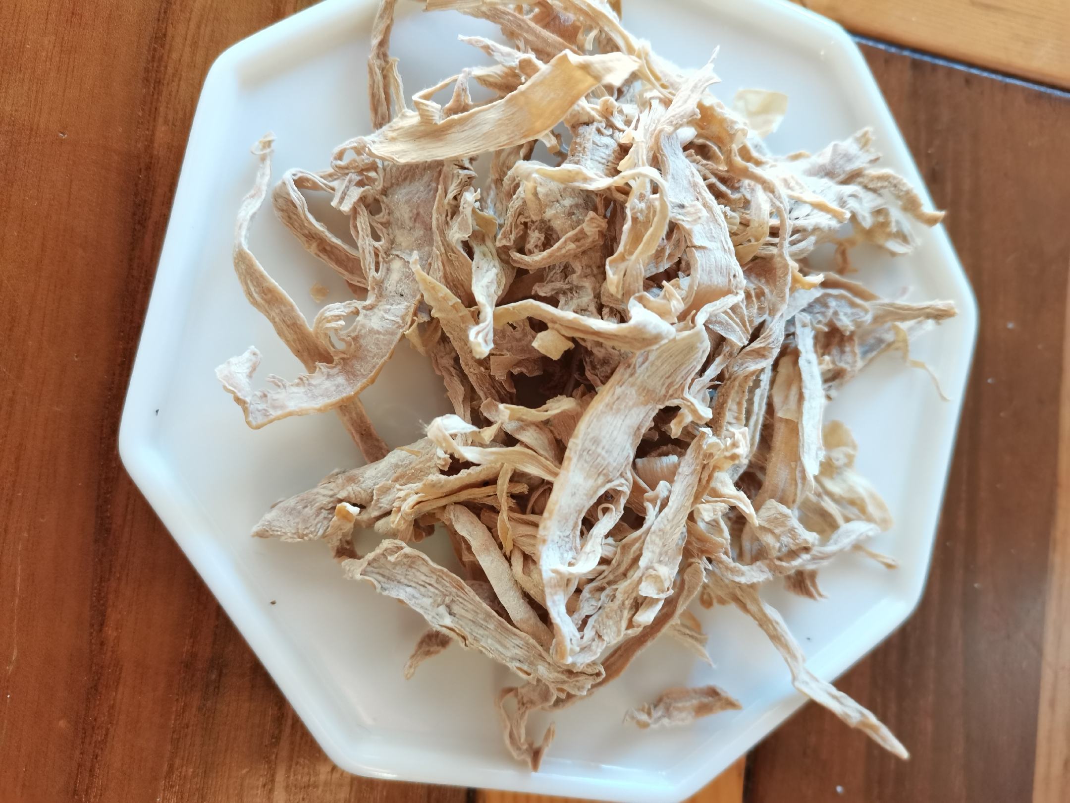 新鲜干燥的白胡椒颗粒特写,背景为木质桌面 白胡椒实物图