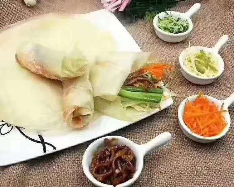 红生菜卷饼成品图,展示完整的卷饼造型,内部可见红生菜、鸡肉和蔬菜丝 红生菜卷饼成品图