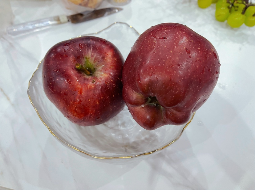 不锈钢锅中正在熬煮的花牛苹果块，糖水微沸，果肉呈半透明状，蒸汽升腾