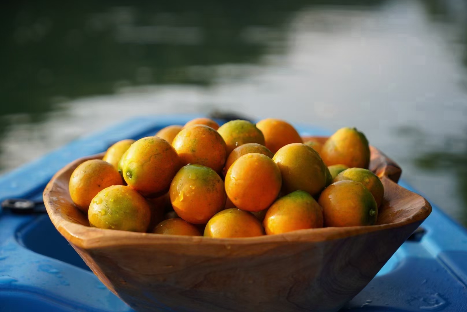 展示新鲜金桔果实与自制金桔水的对比画面,背景为厨房环境,突显自然与健康感 金桔果与金桔水的对比图