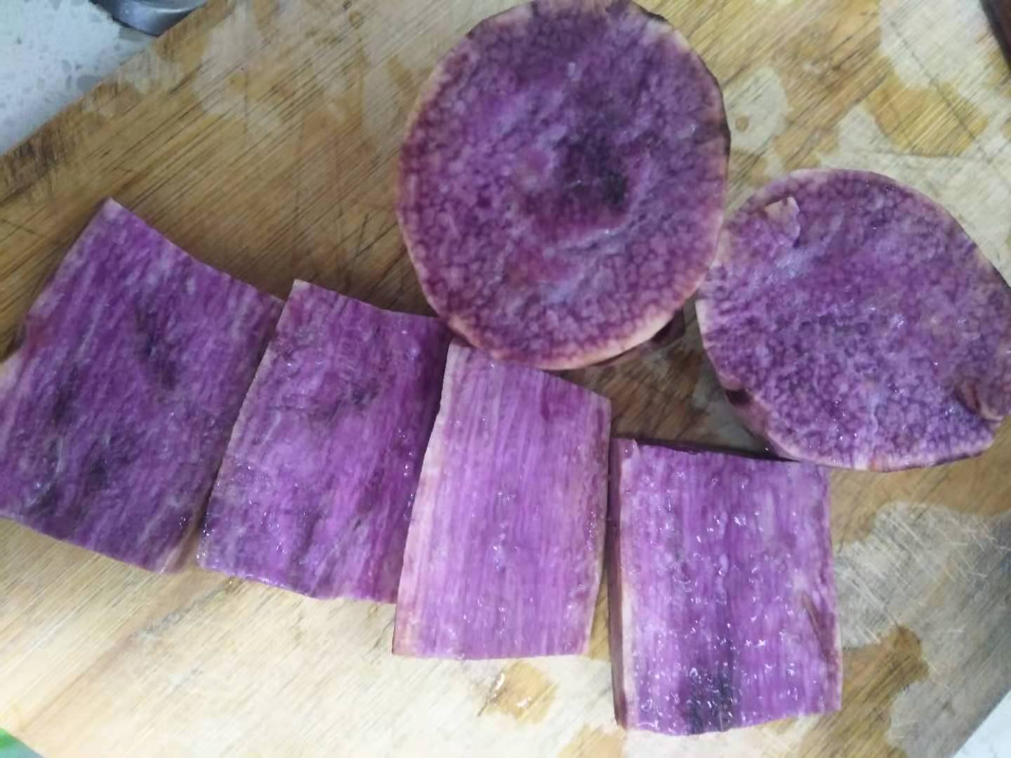 砂锅慢熬淮山红薯小米粥实景,突出文火工艺与精准食材配比 家庭厨房场景:砂锅中慢火熬煮的淮山红薯小米粥,粥体呈淡金琥珀色,表面浮着细小气泡,旁边摆放切好的淮山片与红薯丁,案台铺有竹制蒸垫与计量勺