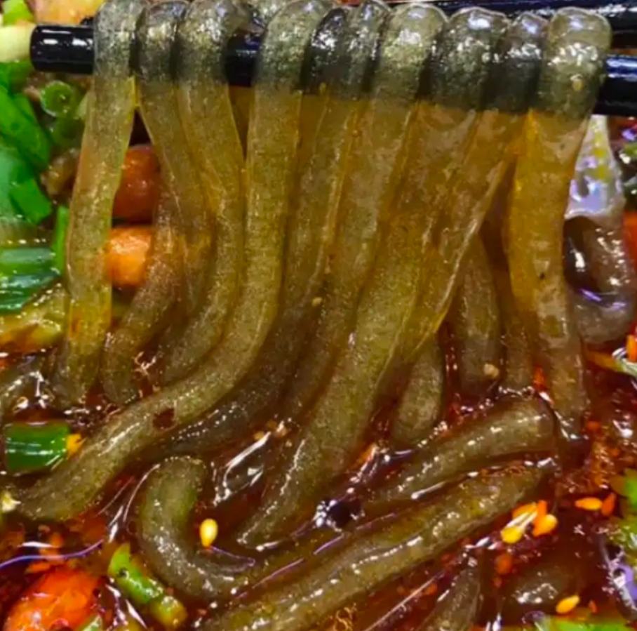 展示一碗调好料的豌豆凉粉,配有辣椒油、蒜泥、黄瓜丝和花生米 豌豆凉粉成品展示