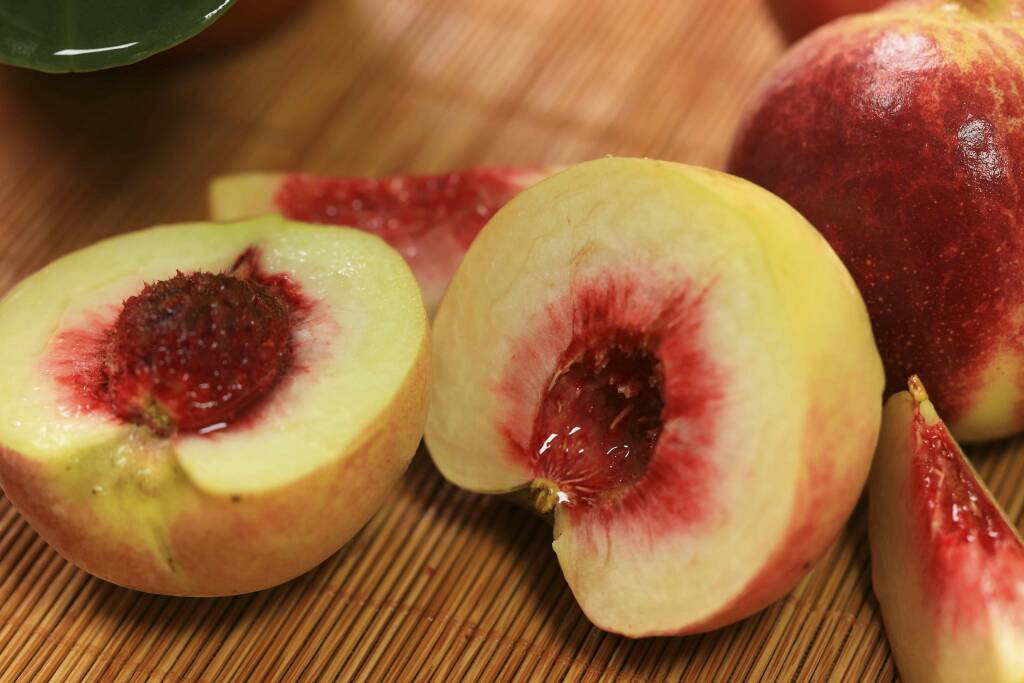 一颗成熟的冬桃,表皮红润,切开后果肉鲜嫩多汁 冬桃果实特写