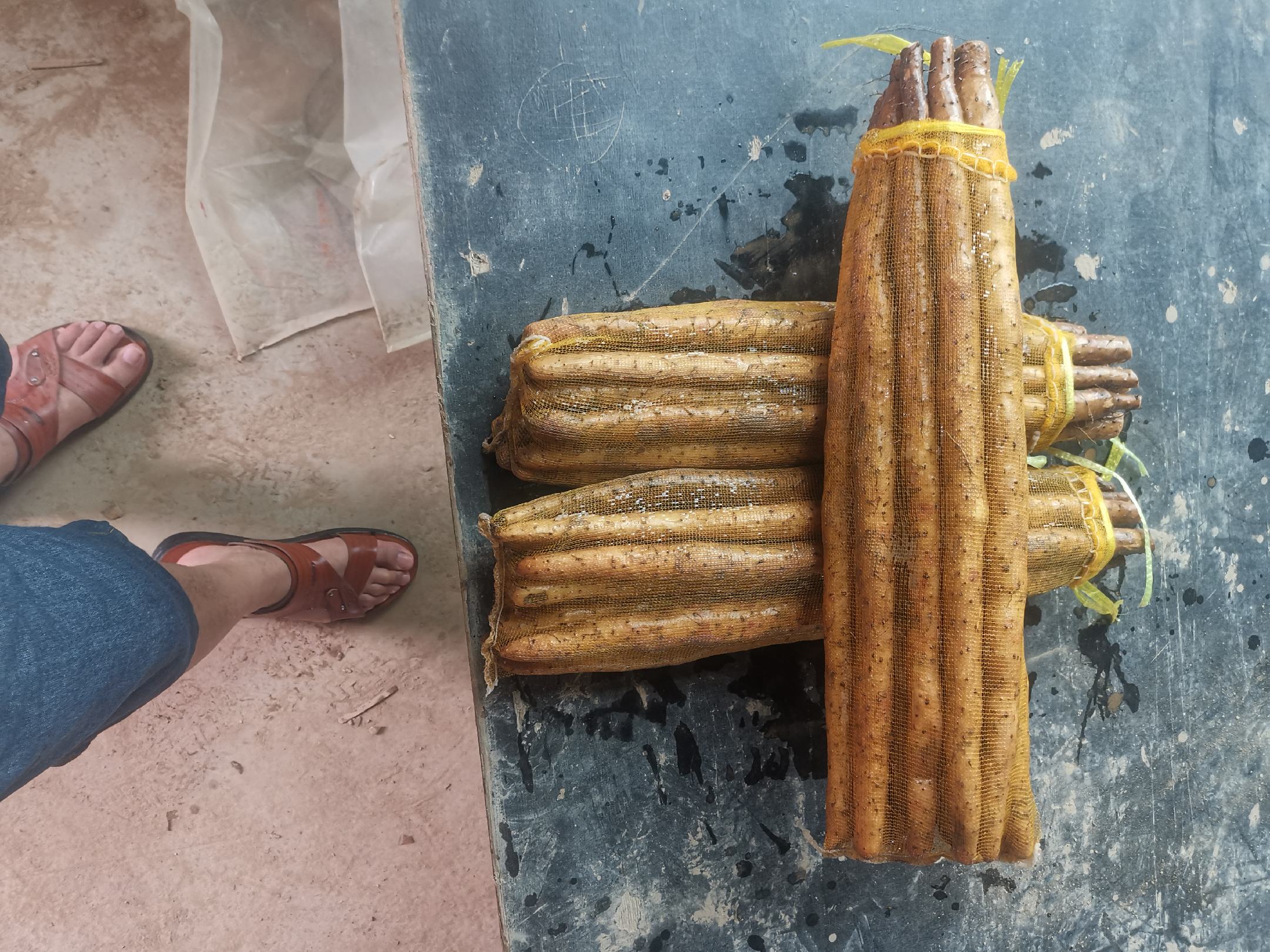 一款设计简洁的白色硬壳礼盒摆放在浅灰色桌面上,盒身印有‘小白嘴山药’字样及山水风格图案,打开的盒盖内整齐码放着六段用牛皮纸包裹的小白嘴山药,旁边配有产品说明书和二维码溯源标签,整体风格高端、干净,体现品牌化农业形象 包装精美的小白嘴山药礼盒展示