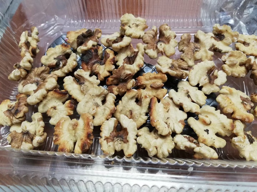 一个透明密封罐中装满去壳的薄皮核桃仁,罐体标注‘已冷藏’标签,旁边放置温度计显示4℃,背景为冰箱冷藏室内部, shelves上整齐排列着其他健康食材,突出科学储藏理念 薄皮核桃储存方法示意图