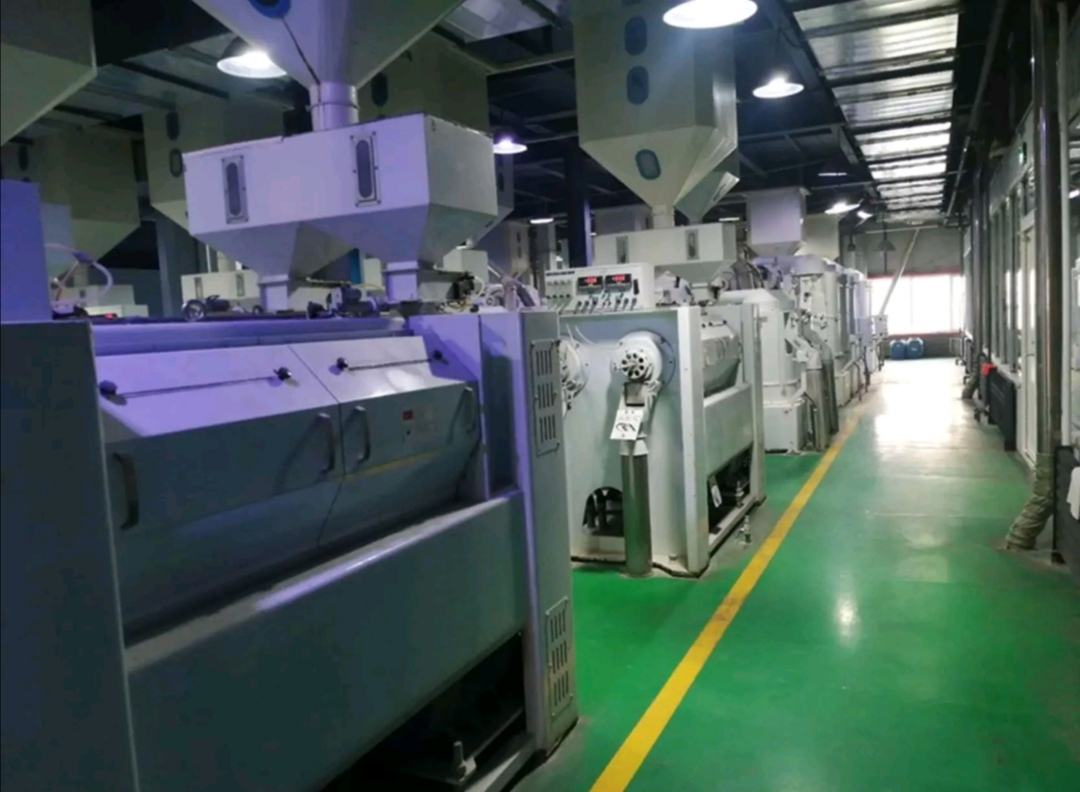 一座现代化大米加工厂内景,自动化流水线正在对艳河长粒香大米进行筛选、抛光、包装作业,工人在监控屏幕前操作设备,传送带上洁白的大米缓缓流动,体现科技赋能农业的高效与洁净 现代化大米加工厂内部场景