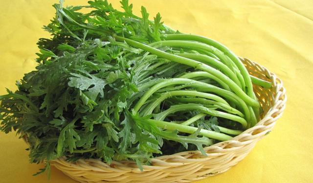 茼蒿与鸡蛋、木耳一起翻炒的画面,展现健康搭配方式 茼蒿与其他食材搭配炒制图