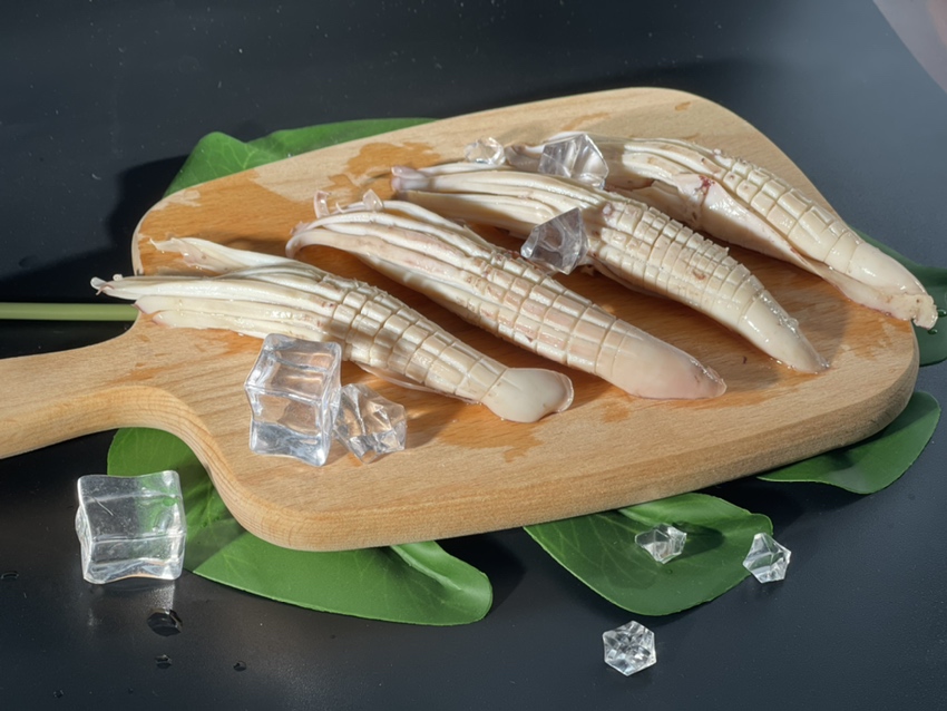 图片说明:一盘香辣鱿鱼旁边放着一杯冰镇可乐,展现常见的饮食搭配场景 鱿鱼与可乐同食的餐桌场景