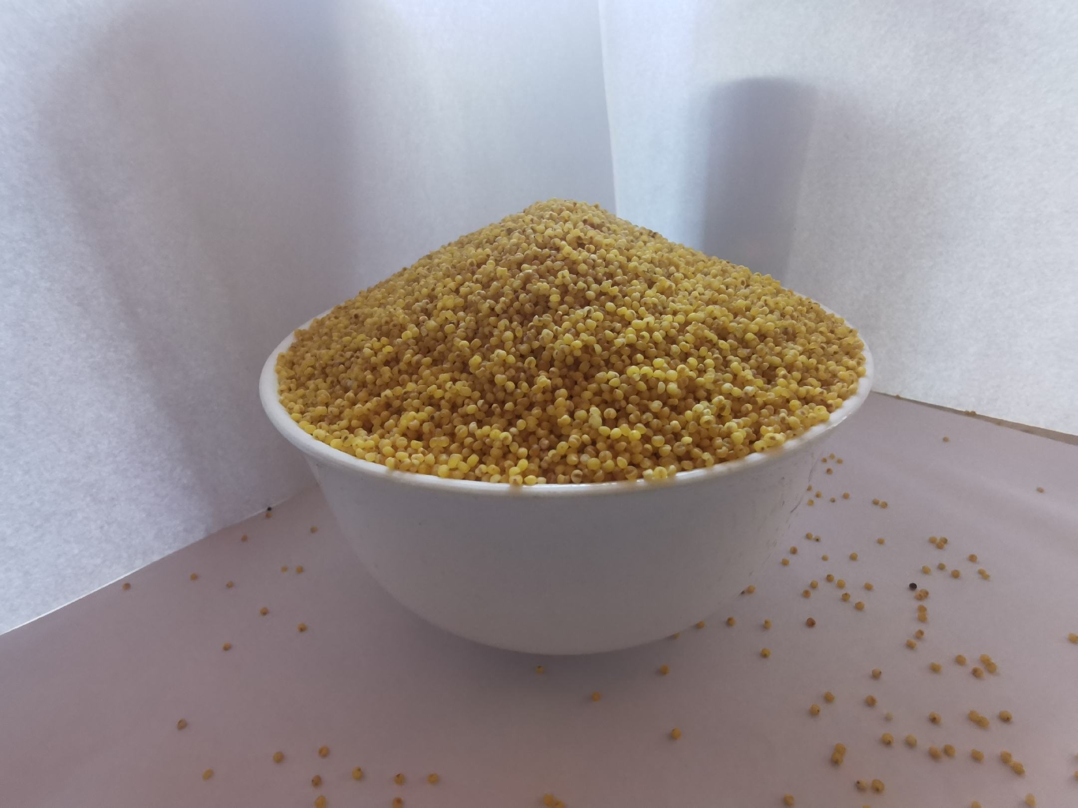 玻璃杯盛装的翡翠色菠菜小米苹果米糊,表面光滑无气泡,可见细微苹果果肉颗粒和浅金色小米悬浮物,杯壁无挂渣,背景为原木砧板与新鲜菠菜叶、苹果片、小米碗 菠菜小米苹果米糊成品特写