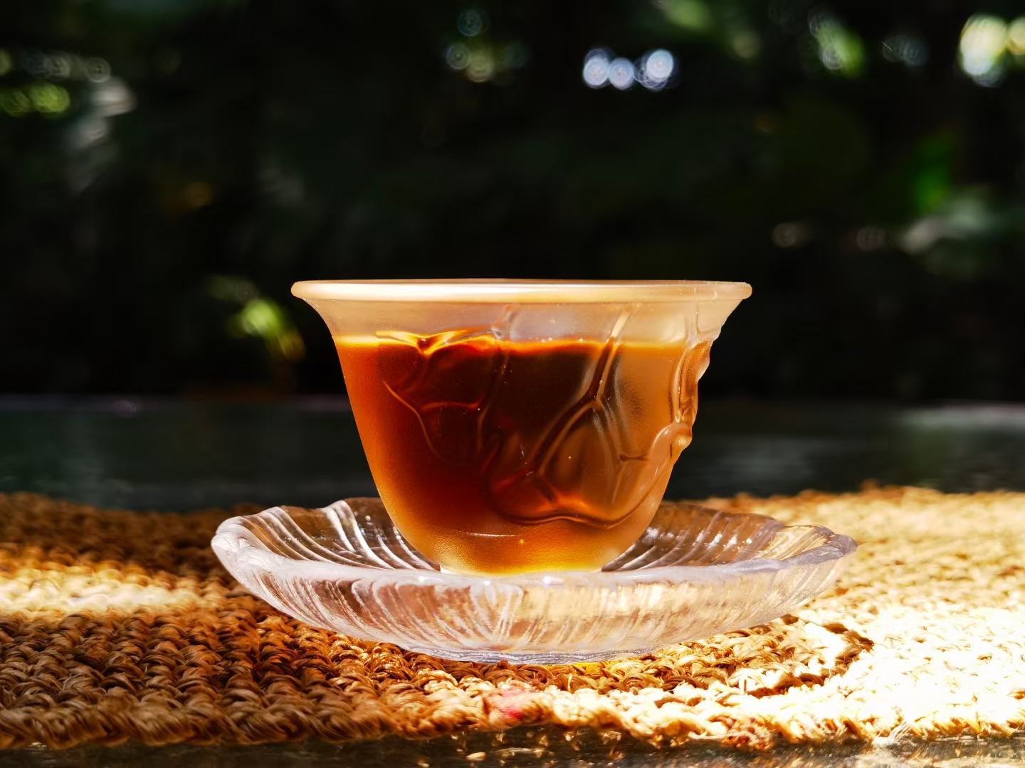 潮汕工夫茶席上的红桃粿：青瓷茶盘中摆着三枚切片红桃粿，旁边是紫砂小壶与三只白瓷茶杯，茶汤金黄透亮，粿片边缘微泛油光，可见清晰的豆沙与花生颗粒
