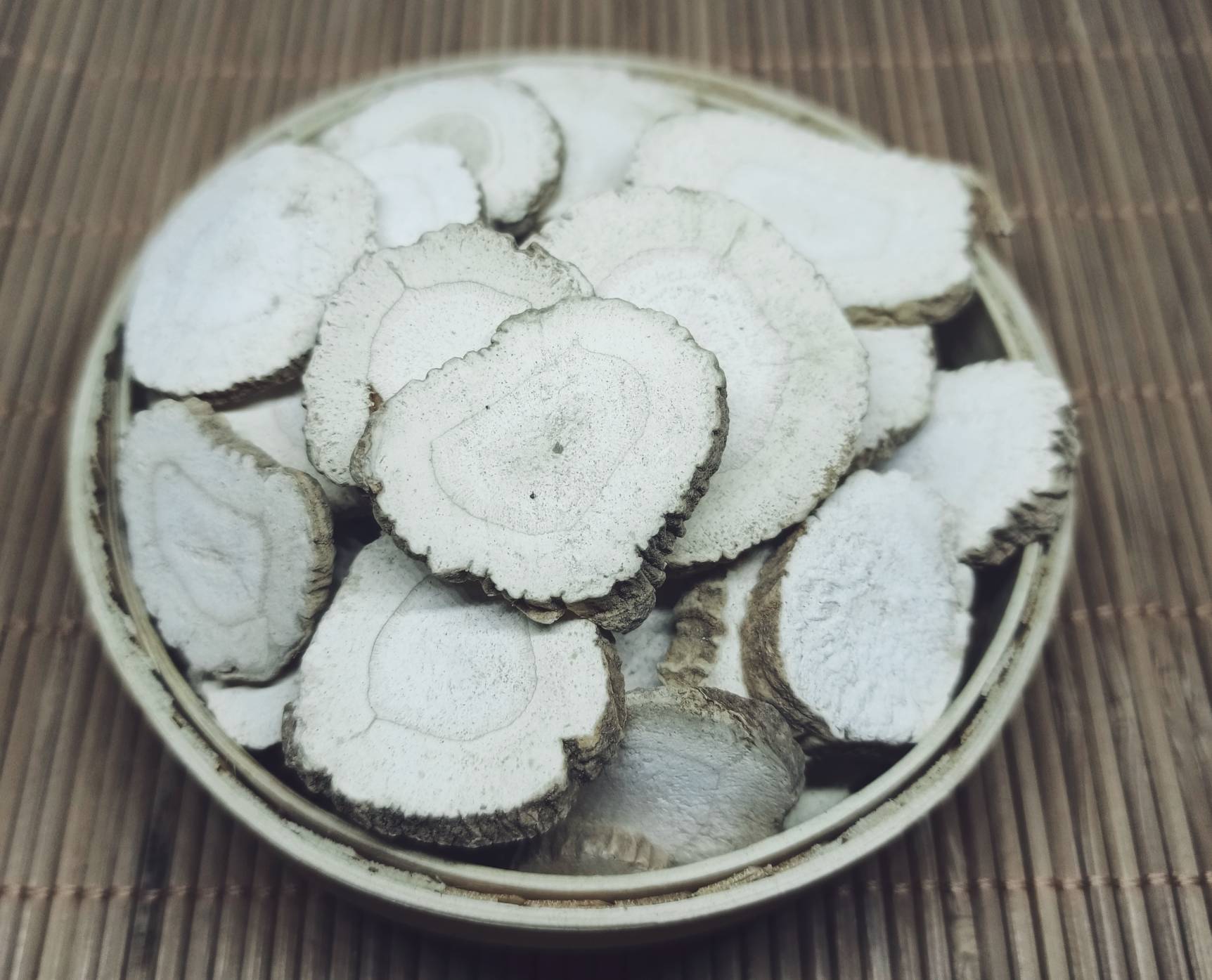 玻璃碗中并列摆放:左侧为干燥整齐的黄芩饮片(金黄色条状,表面细腻无裂纹),右侧为新鲜猪肝切片(褐红油润,边缘完整无碎屑),背景为竹制砧板与不锈钢药碾 黄芩与猪肝食材分装特写