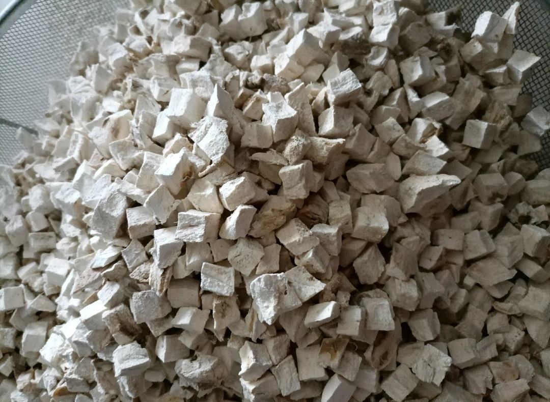 粉葛传统加工场景：农民在阳光下摊晒切片后的粉葛片，片形均匀厚薄一致，表面泛出细腻白霜状淀粉结晶