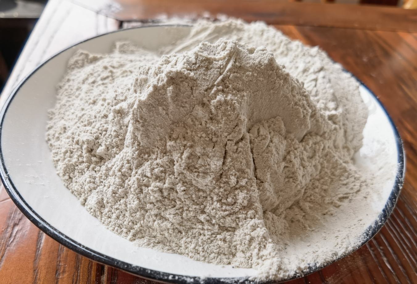 老姜祛湿经典食谱：砂锅中熬煮的老姜茯苓茶，汤色琥珀透亮，浮有姜片与茯苓块，旁边配青瓷碗盛装，背景为中式厨房木质台面