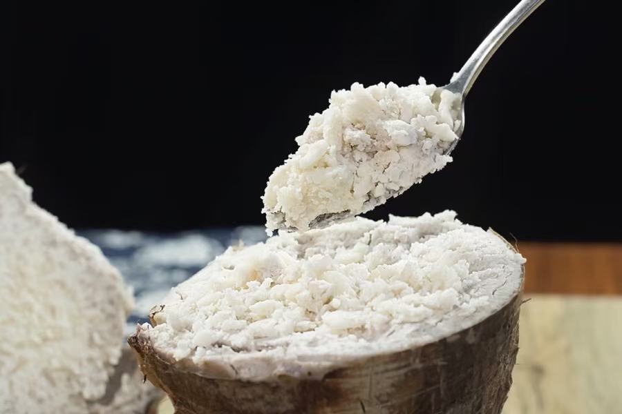 一名厨师正在不粘锅中用硅胶刮刀翻炒金黄色的荔浦芋头泥,锅中冒出轻微热气,黄油与淡奶油已融入芋泥中,质地浓稠光滑,灶台背景整洁明亮 炒制荔浦芋头芋泥的过程特写