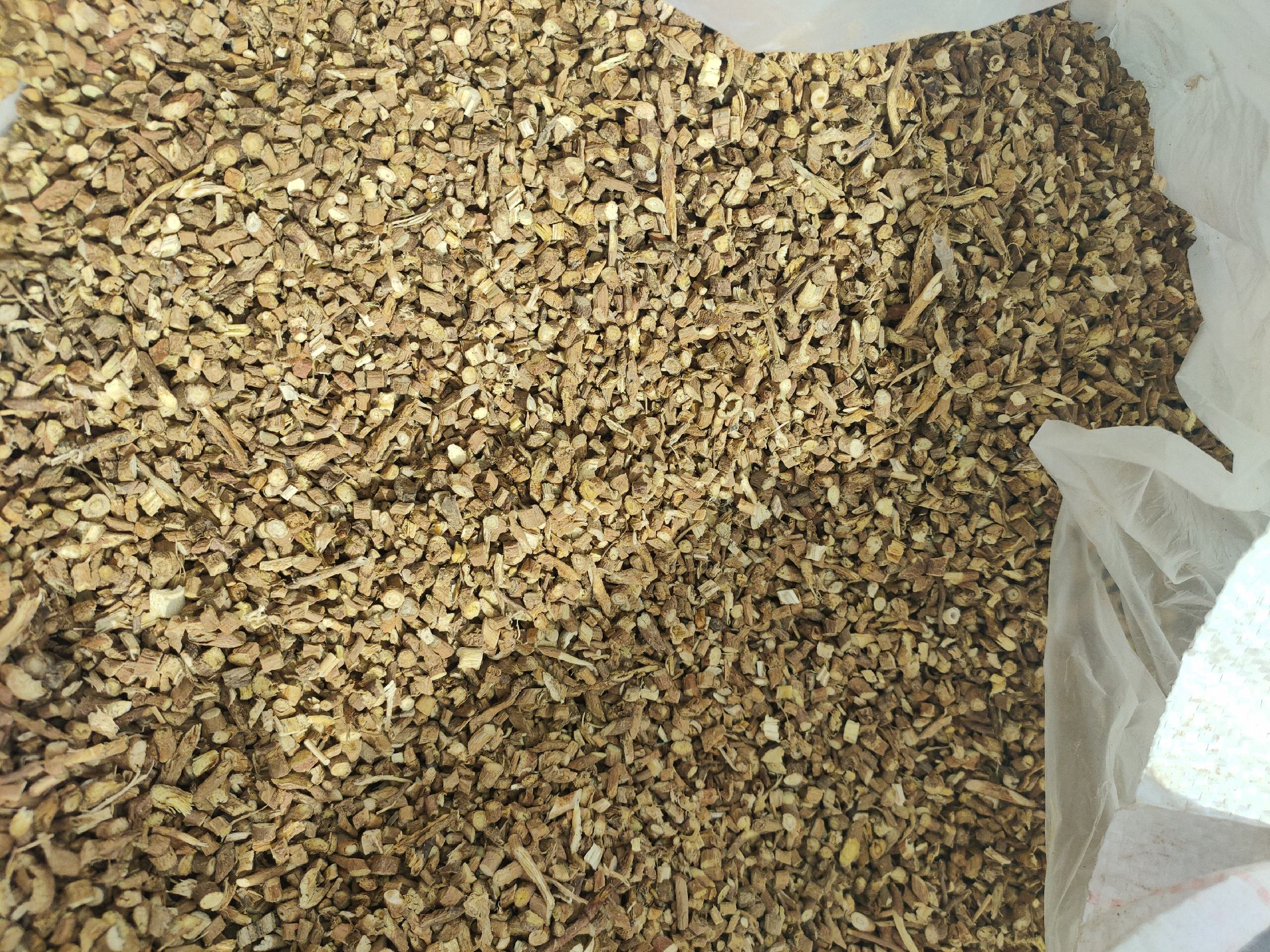 高清微距摄影:呈圆柱形、表面黄褐色至浅棕色,具纵皱纹及支根痕;断面淡黄白色,木质部呈放射状纹理,皮部较宽,气微香,味微苦而带清凉感;药材饮片厚度约2–3mm,切面平整,可见明显形成层环 北柴胡干燥根药材特写