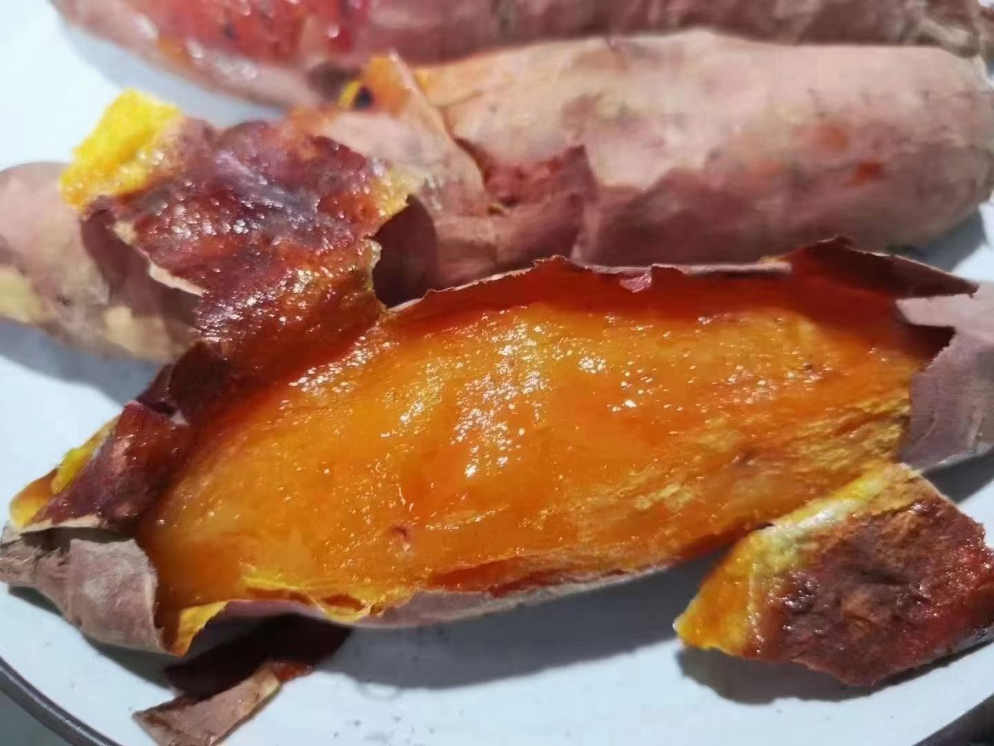 刚出炉的烟薯25号横切面高清特写:外皮焦糖化呈深栗色,内瓤饱满橙红,中心区域呈半透明琥珀色流心状,蜜汁微微渗出,表面可见细腻气孔与金丝糖络分布,搭配竹制砧板与不锈钢小勺,凸显‘冰淇淋口感’视觉特征 烤制完成的烟薯25号切开展示图