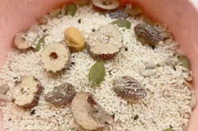 一碗盛在瓷碗中的白莲子粥,旁边配有榨菜和鸡蛋,展示早餐搭配 白莲子粥成品图