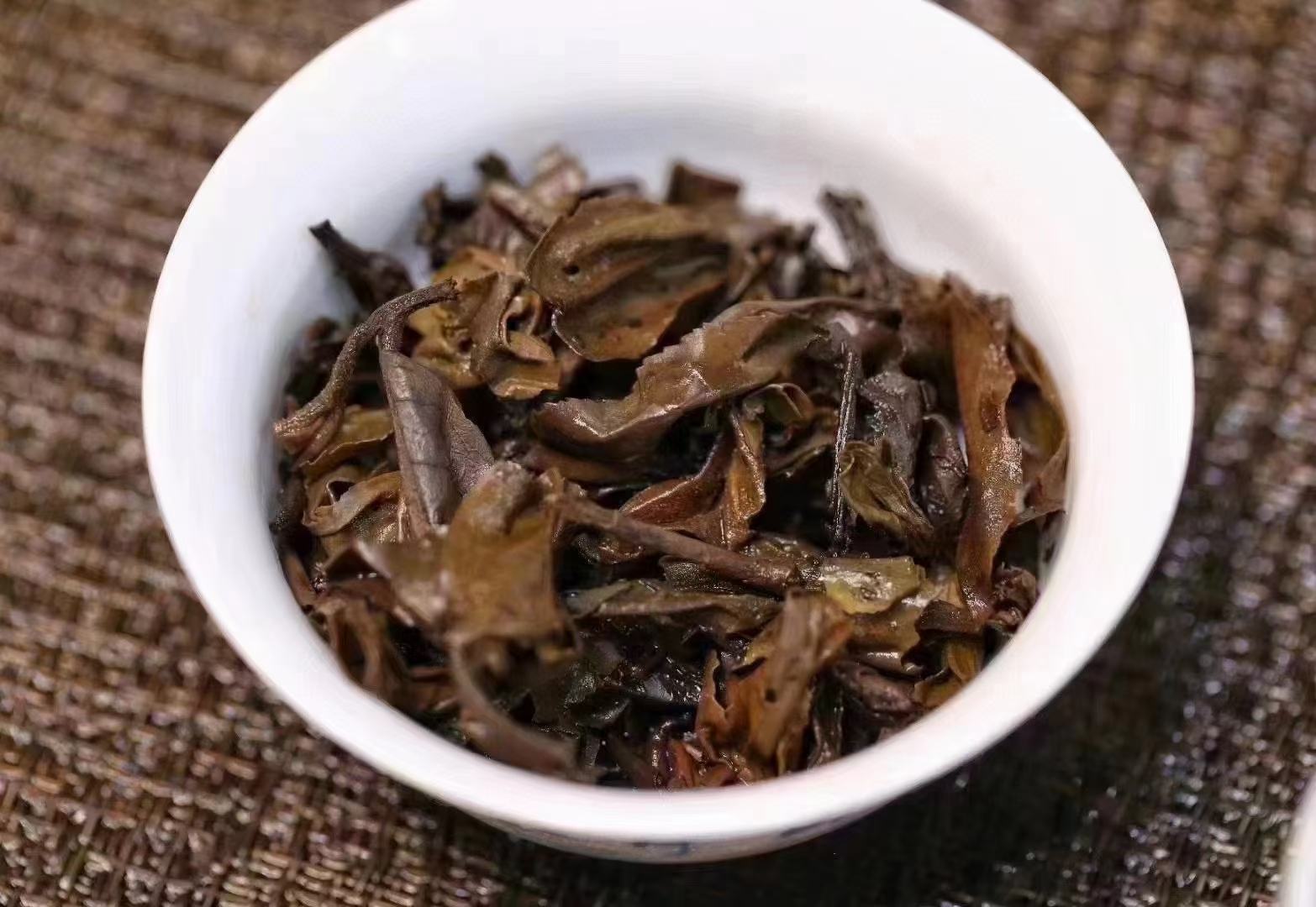 白萝卜切丝与陈年熟普洱茶汤同置青瓷碗中，背景为木质餐桌与冬季窗景，茶汤呈红浓透亮琥珀色，萝卜丝洁白脆嫩带微透明感，表面凝结细小水珠，体现“热茶暖润、萝卜生津”的温通意象
