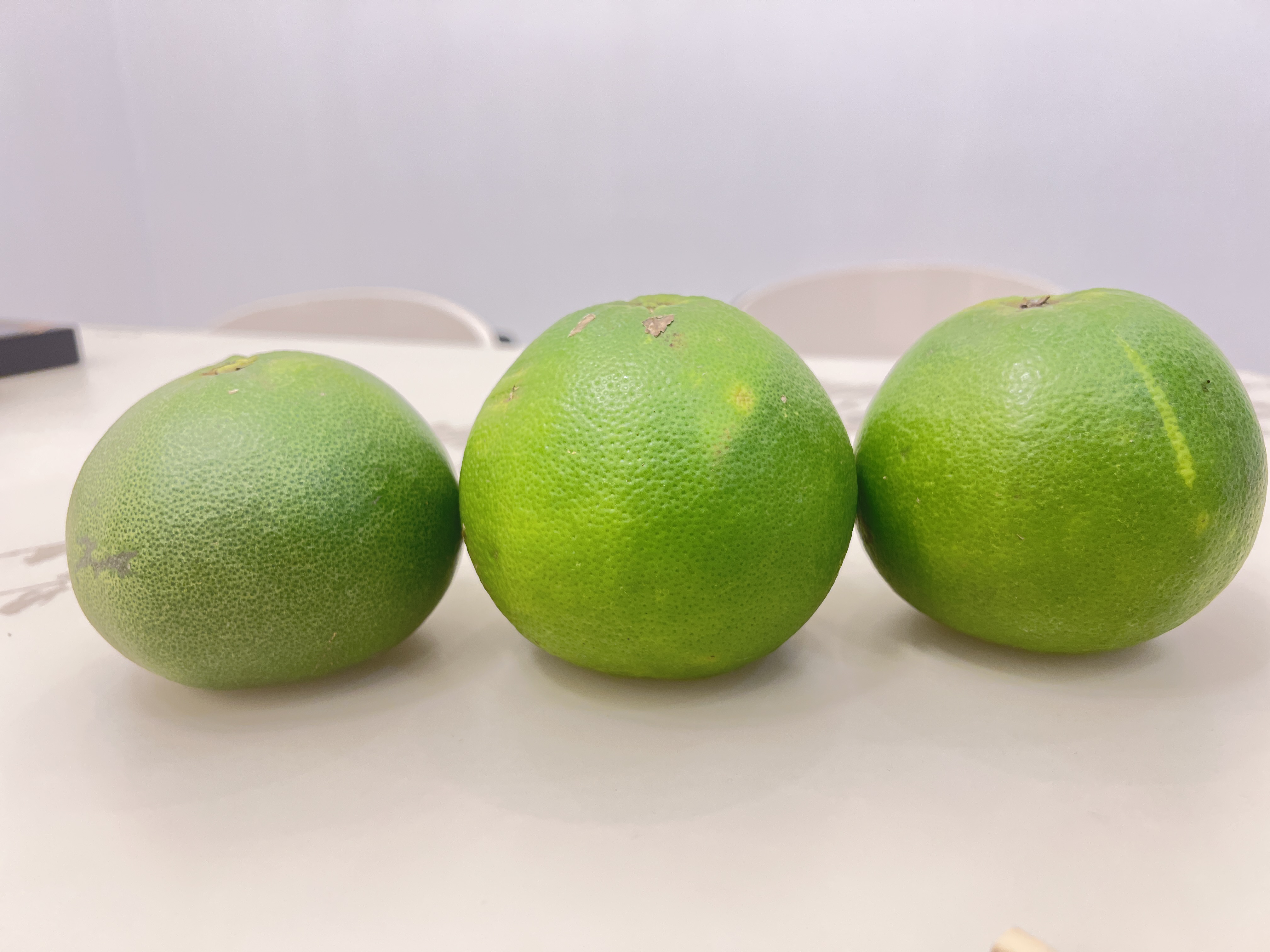 三颗并排摆放的葡萄柚:左侧为白色果肉品种,中间为粉红品种,右侧为深红西柚,背景标注‘White, Pink, Ruby Red’字样,用于展示颜色差异 不同品种葡萄柚对比图