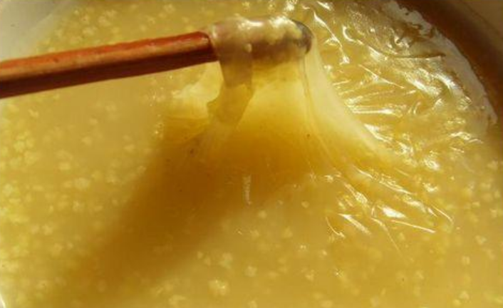 一碗菠菜鸡蛋粥,表面漂浮着金黄色的蛋花和绿色菠菜碎 菠菜鸡蛋粥成品展示