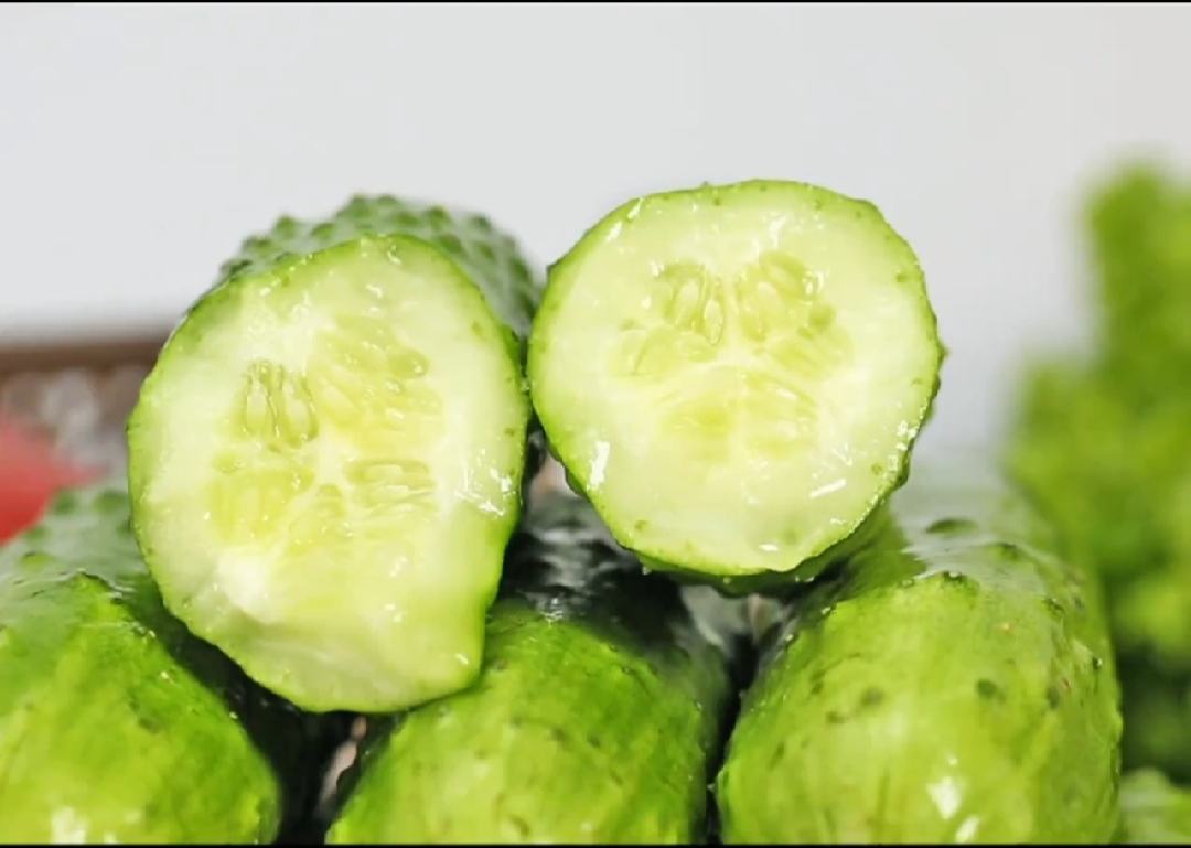 一个被横向切开的旱黄瓜展示其内部结构:果肉洁白致密,中心籽腔较小,种子呈淡黄色且未完全成熟,周围汁液饱满但不外溢,刀面光洁无纤维感,突出其新鲜与高品质 切开的旱黄瓜横截面特写