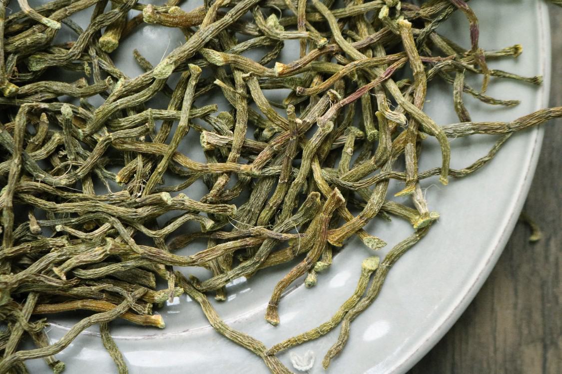 高清俯拍:左上角为金黄铁皮石斛干条(带明显环纹),右上角为薄透淡黄花旗参切片与浅黄生晒参片对比,左下为新鲜猪脊骨(带红润骨髓断面),右下为去核红枣、宁夏枸杞、老姜片及新会陈皮丝,背景为素色竹编托盘 石斛花旗参煲猪骨核心食材特写