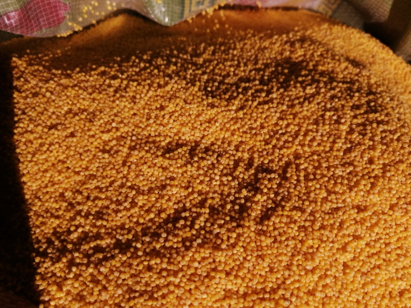 一家现代化超市的粮食货架特写,整齐摆放着多个品牌的真空包装小米,包装上有明显的‘有机小米’‘黄金小米’字样,旁边配有二维码和营养成分表,背景可见其他杂粮如红豆、绿豆、燕麦等,体现当代人对健康主食的选择趋势 现代超市中小米产品陈列架