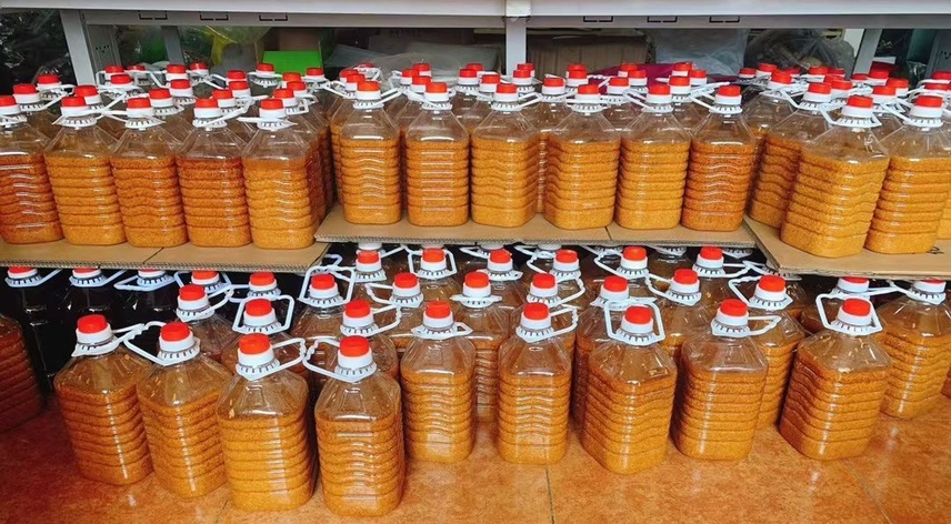 展示装好李子、糖和酒的玻璃罐,酒液清澈,李子沉于罐底,整体呈现出诱人的色泽 李子酒泡制过程