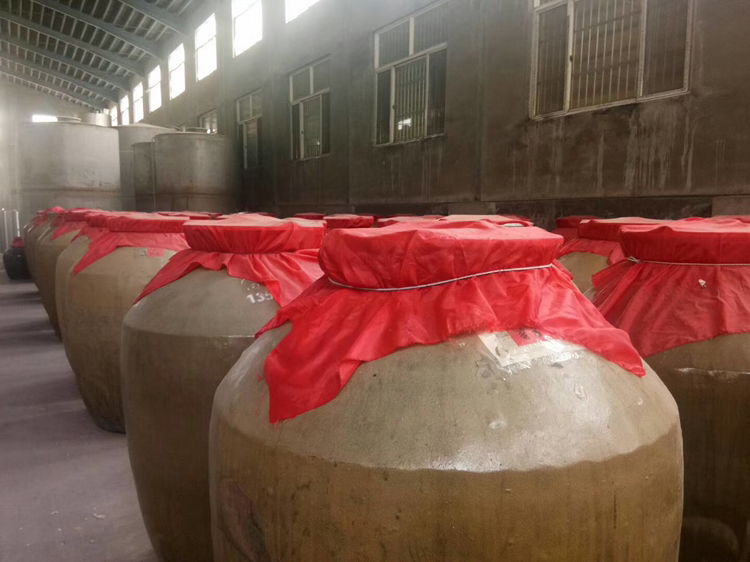 黄果柑酒在玻璃瓶中进行发酵过程,旁边放有搅拌棒与密封盖 黄果柑酒发酵过程中搅拌与密封示意图