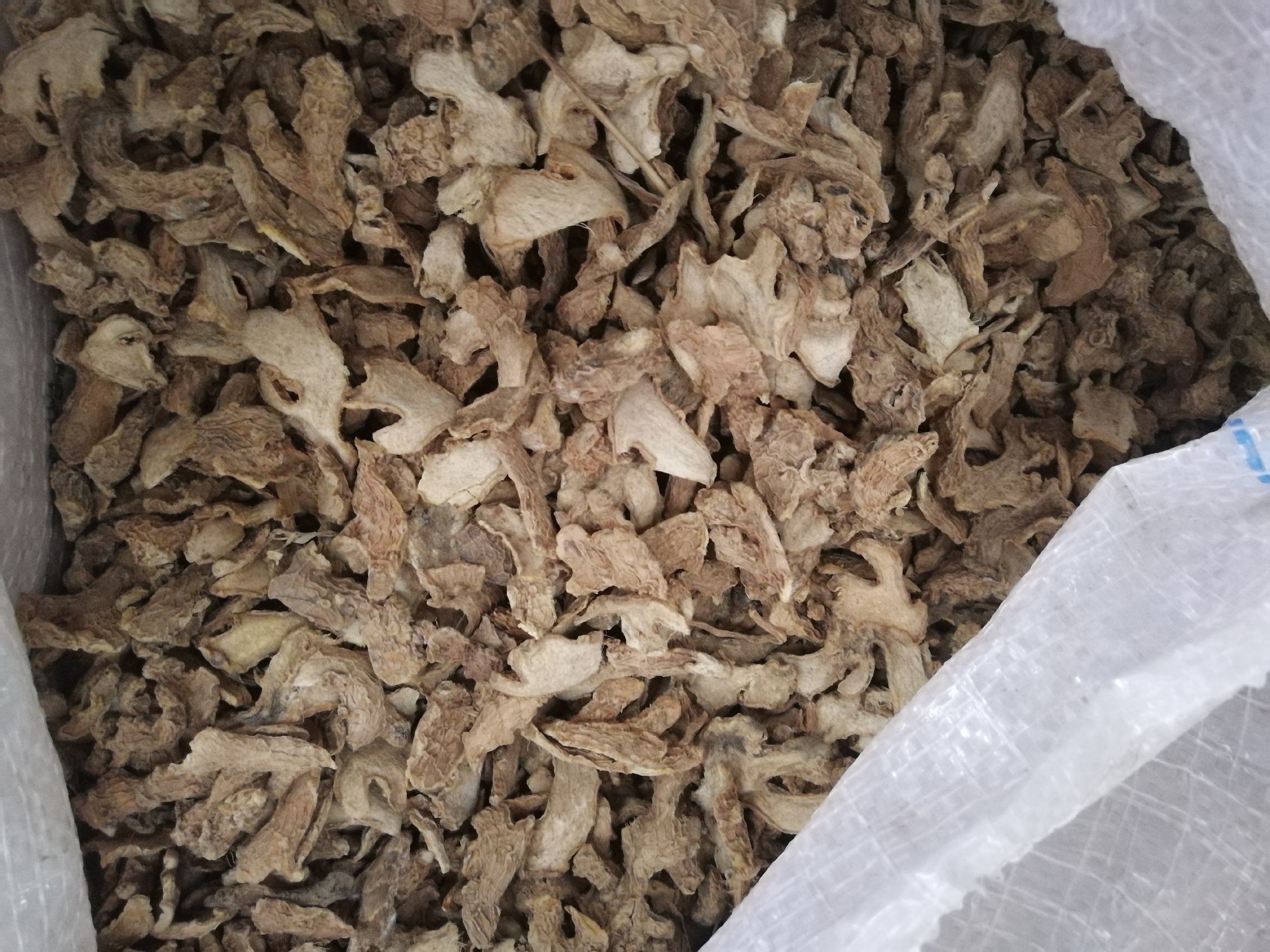 高清微距摄影:透明真空铝箔袋平铺于白色亚麻布上,袋内整齐叠放金黄色半透明脱水姜片,边缘微卷曲,表面泛细腻油润光泽;袋体印有‘有机生姜·低温脱水’字样,光影层次丰富,凸显干燥工艺带来的质感升华 真空包装脱水生姜特写图