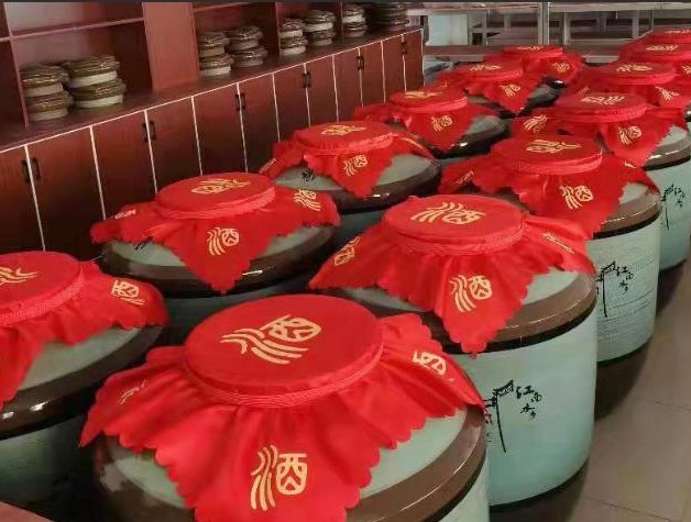 红梅果泡酒场景,展示玻璃瓶中浸泡的红梅果与白酒,背景为传统中式厨房 红梅果泡酒图