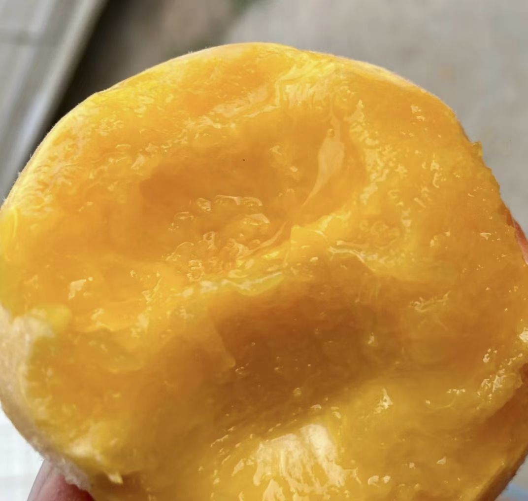 切开的黄桃展示其金黄色果肉与果核结构,果肉饱满多汁 黄桃切片展示果肉结构