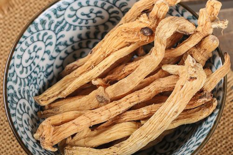 黄金玉竹酒成品展示:酒液呈琥珀金色,晶莹剔透,搭配原产地金镶玉竹植株,突出天然原料来源 金黄色的玉竹酒液倒入透明玻璃杯中,酒体清澈透亮,背景为新鲜采摘的金镶玉竹植株