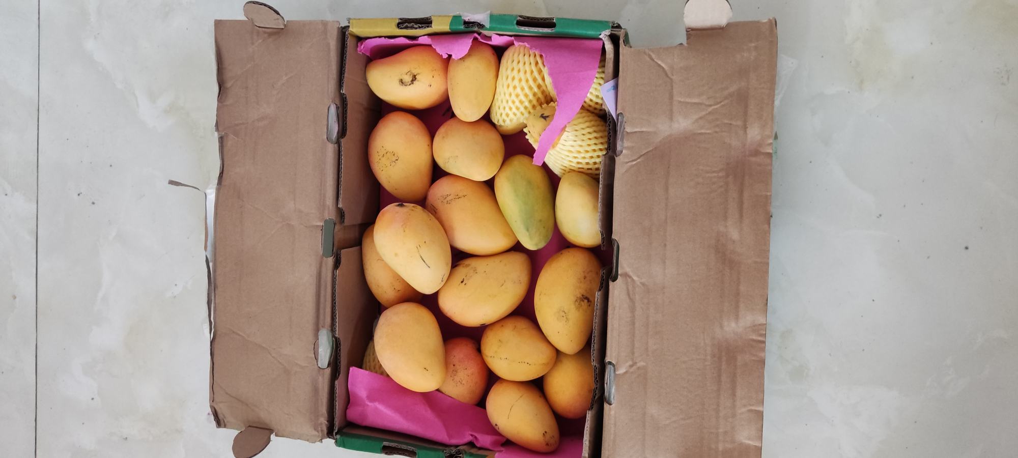 小台芒深加工产品矩阵：玻璃瓶装NFC芒果原汁、铝箔袋装冻干芒果脆片、真空小袋装去核果肉丁，三款产品并列置于木质砧板上，背景柔焦呈现果园剪影，强调“从枝头到舌尖”的全链路价值