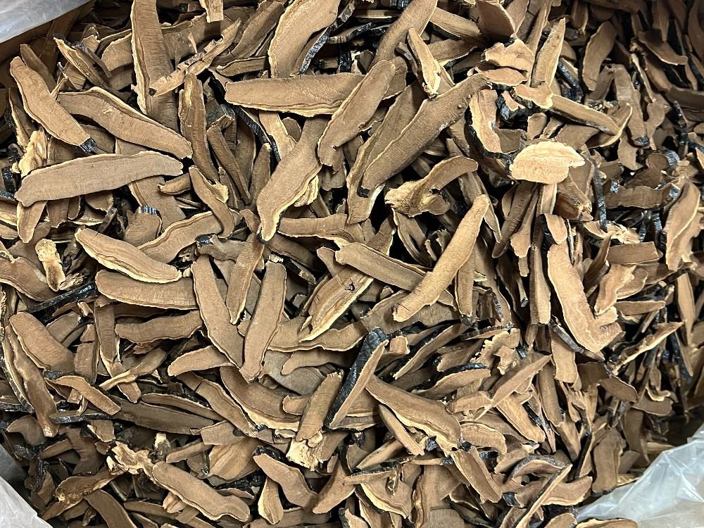 近距离拍摄的干灵芝横切面,清晰显示三层结构:最外层为深棕色角质化表皮,中间为浅黄白色的菌丝体层,内部靠近菌孔端为密集排列的菌管组织;背景干净无杂质,标尺显示切片厚度约为3mm 干灵芝切片剖面结构特写