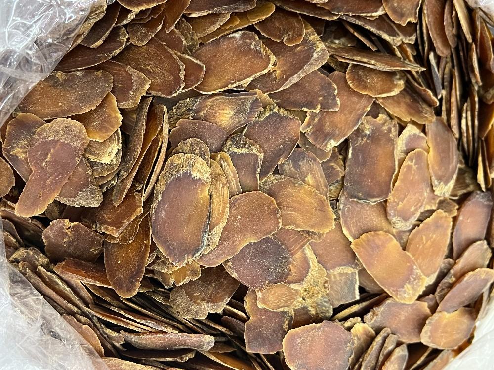 高丽参切片特写：深红褐色、角质样断面、明显环纹与放射状纹理